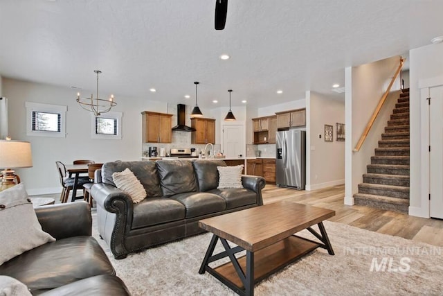 living room featuring sink, a chandelier, and light wood-type flooring