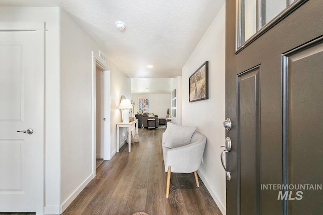 interior space featuring a textured ceiling and dark hardwood / wood-style floors