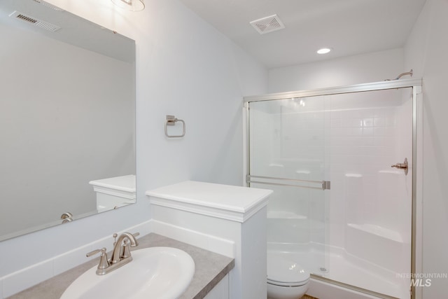 bathroom with vanity, toilet, and a shower with shower door