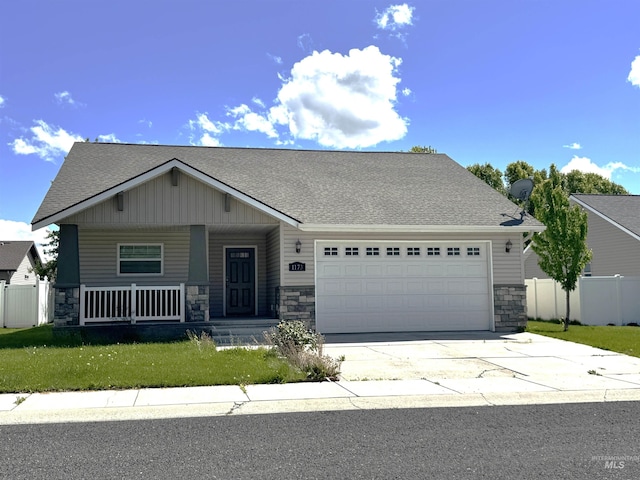 1173 Knoll Ridge Rd, Twin Falls, ID 83301 - craftsman house featuring stone siding, a garage, covered porch, concrete driveway, and a shingled roof