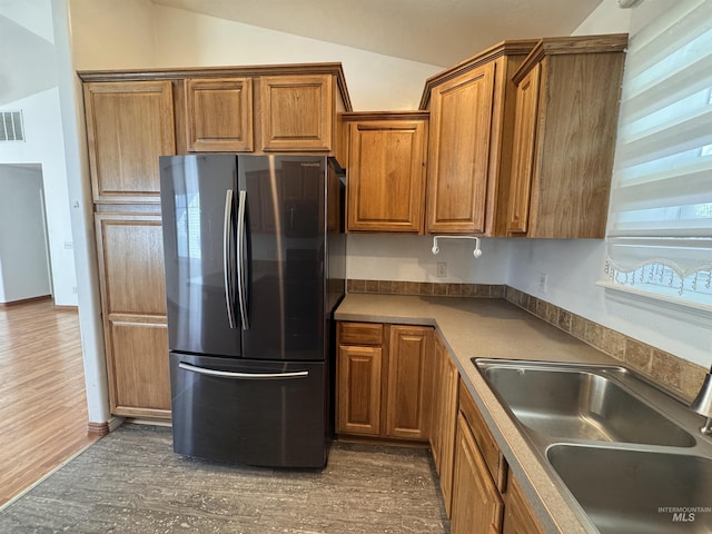 1173 Knoll Ridge Rd, Twin Falls, ID 83301 - kitchen featuring freestanding refrigerator, vaulted ceiling, a sink, brown cabinets, and dark wood-type flooring