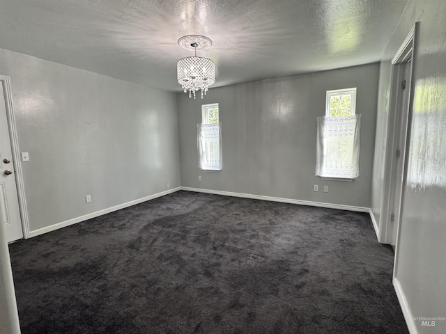 1173 Knoll Ridge Rd, Twin Falls, ID 83301 - unfurnished room with a chandelier, baseboards, healthy amount of natural light, and dark colored carpet