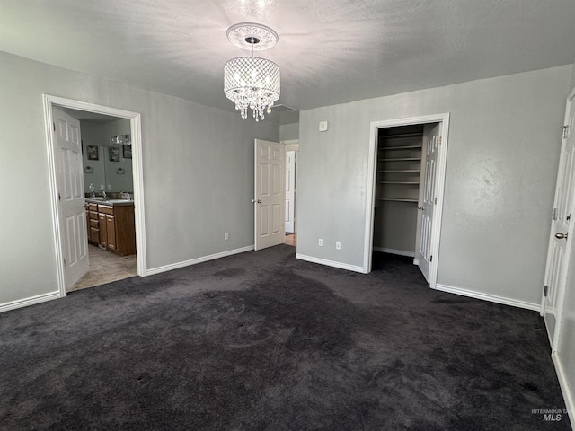 1173 Knoll Ridge Rd, Twin Falls, ID 83301 - unfurnished bedroom with a chandelier, dark carpet, baseboards, ensuite bathroom, and a closet