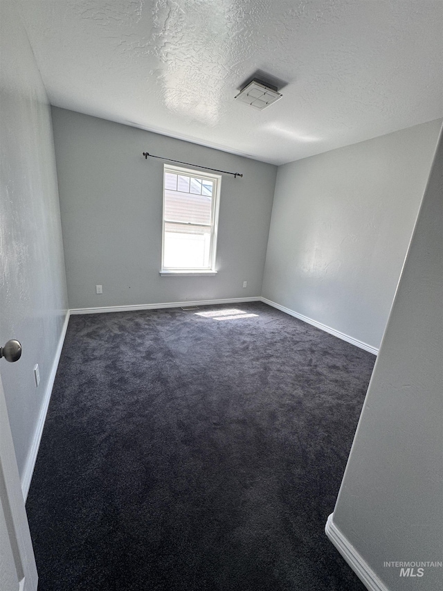 1173 Knoll Ridge Rd, Twin Falls, ID 83301 - empty room featuring a textured ceiling, dark colored carpet, and baseboards