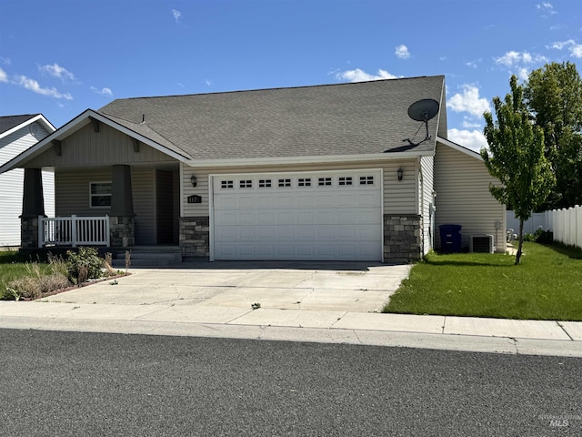 1173 Knoll Ridge Rd, Twin Falls, ID 83301 - view of front of property featuring stone siding, an attached garage, covered porch, concrete driveway, and a shingled roof