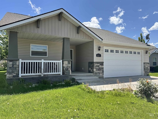 1173 Knoll Ridge Rd, Twin Falls, ID 83301 - view of front of home featuring stone siding, a porch, driveway, and an attached garage