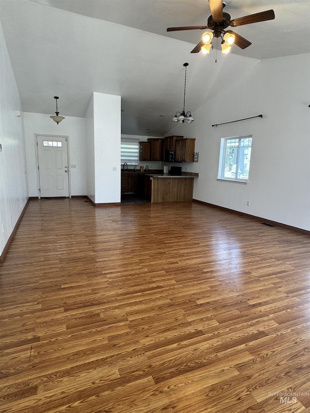 1173 Knoll Ridge Rd, Twin Falls, ID 83301 - unfurnished living room featuring a ceiling fan, high vaulted ceiling, dark wood-style flooring, baseboards, and a chandelier