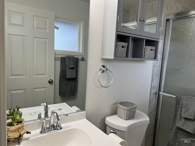 bathroom featuring an enclosed shower, toilet, and sink