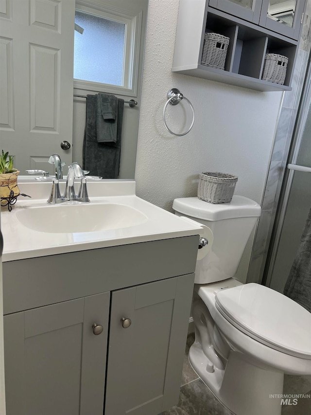 bathroom featuring tile floors, toilet, and vanity with extensive cabinet space