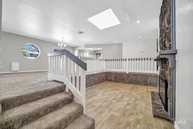 790 Academic Dr, Twin Falls, ID 83301 - stairs with an inviting chandelier, a textured ceiling, a skylight, wood-type flooring, and baseboards