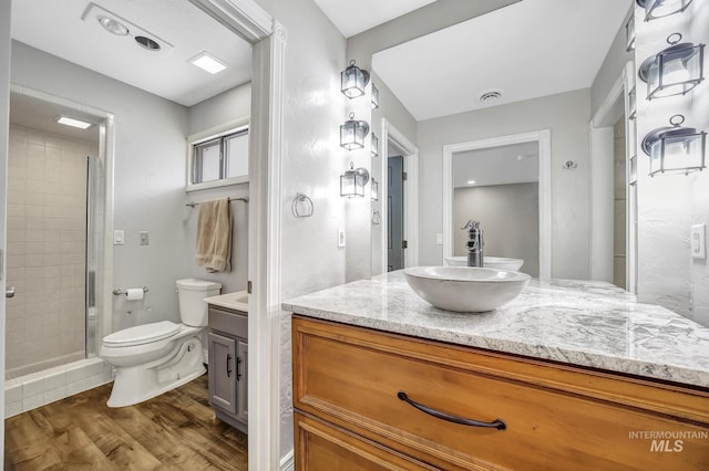 790 Academic Dr, Twin Falls, ID 83301 - full bathroom with vanity, a stall shower, toilet, visible vents, and wood finished floors