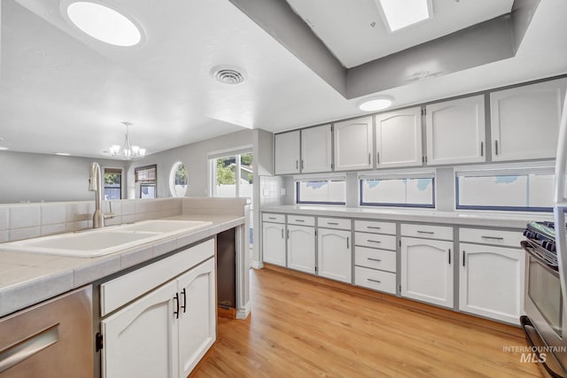 790 Academic Dr, Twin Falls, ID 83301 - kitchen with range with gas cooktop, visible vents, a notable chandelier, a sink, and light wood-style floors