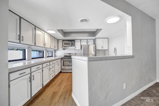 790 Academic Dr, Twin Falls, ID 83301 - kitchen featuring appliances with stainless steel finishes, a textured wall, light countertops, and visible vents