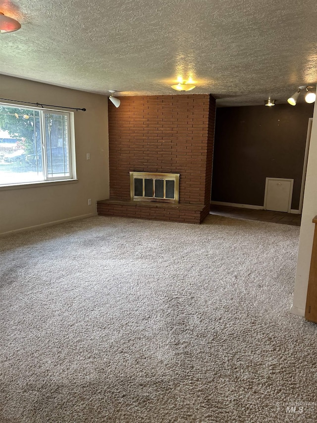 2320 S Illinois, Caldwell, ID 83605 - spare room with a textured ceiling, carpet, and a brick fireplace
