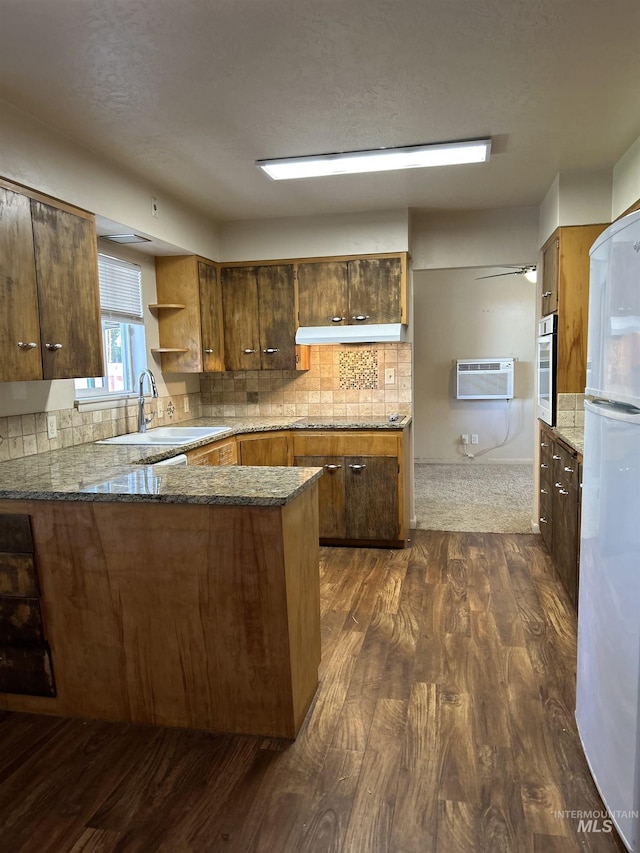 2320 S Illinois, Caldwell, ID 83605 - kitchen with freestanding refrigerator, a wall mounted AC, dark wood-style flooring, stainless steel oven, and under cabinet range hood