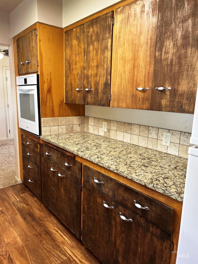 2320 S Illinois, Caldwell, ID 83605 - kitchen with white oven, dark wood finished floors, light stone counters, and tasteful backsplash