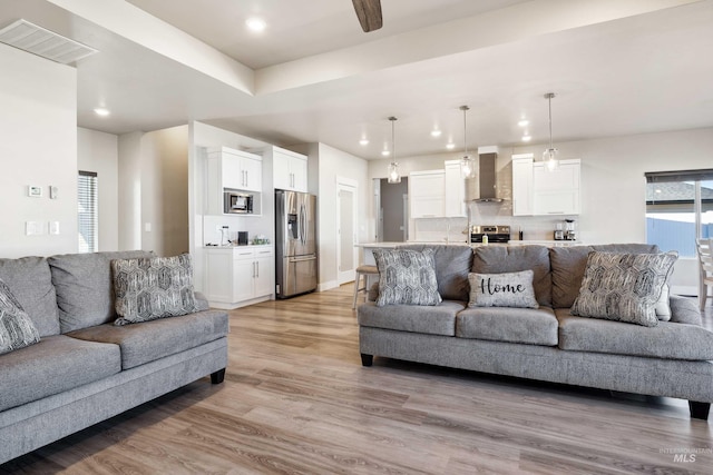 living area featuring recessed lighting, visible vents, baseboards, and light wood-style flooring