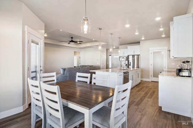 dining room featuring a ceiling fan, recessed lighting, wood finished floors, and baseboards