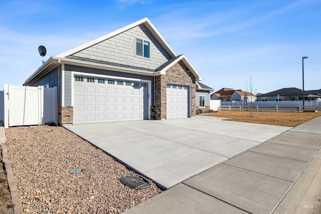 view of property exterior featuring fence, stone siding, and driveway