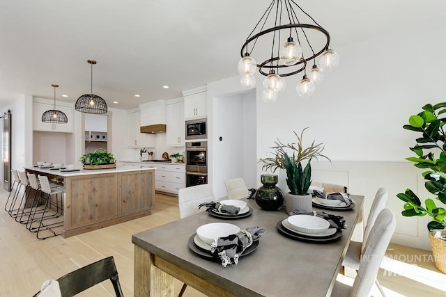 dining space featuring recessed lighting, a notable chandelier, and light wood-style flooring