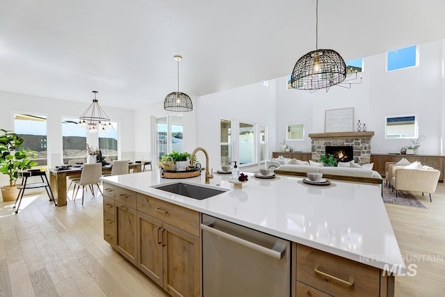 kitchen with a healthy amount of sunlight, dishwasher, an inviting chandelier, and a sink