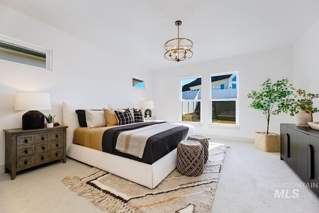 bedroom featuring carpet flooring and a chandelier