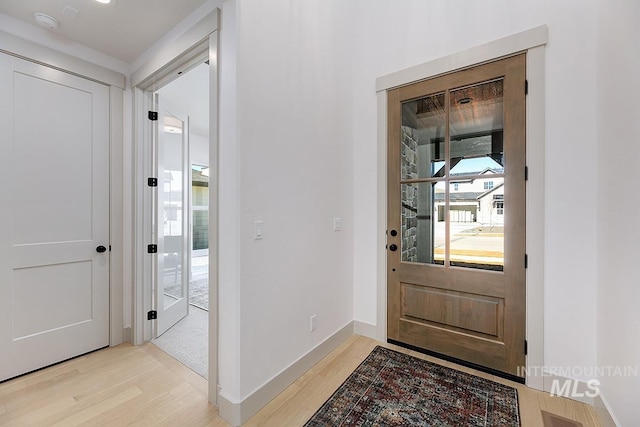 entryway featuring light wood-style flooring and baseboards