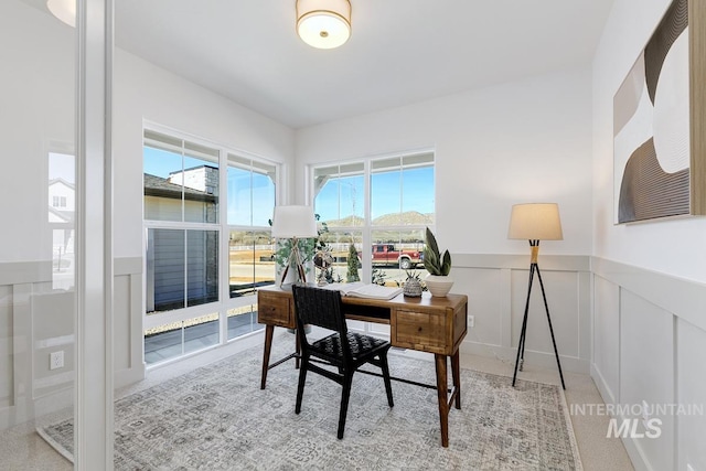 office space with a decorative wall and wainscoting