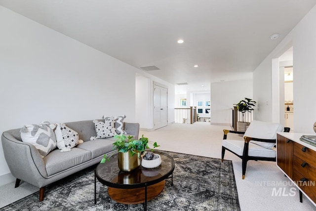 living room with recessed lighting, visible vents, and light colored carpet