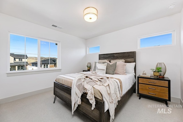 bedroom with visible vents, baseboards, and light colored carpet