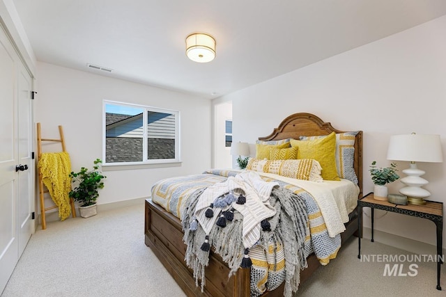 carpeted bedroom with visible vents and baseboards