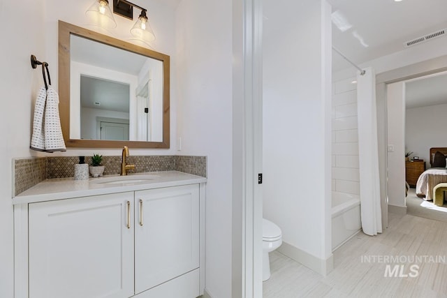 full bathroom featuring visible vents, toilet, backsplash, bathtub / shower combination, and vanity