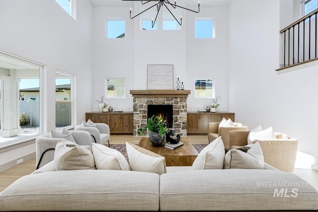 living room with light wood-style floors, an inviting chandelier, and a fireplace