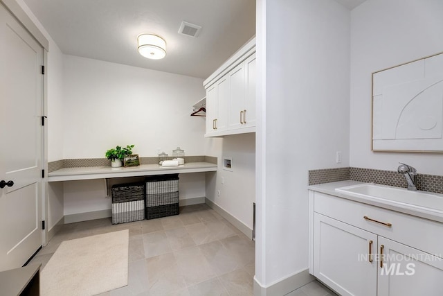 laundry area featuring visible vents, baseboards, hookup for a washing machine, cabinet space, and a sink