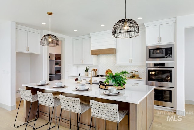 kitchen featuring white cabinetry, light countertops, tasteful backsplash, and stainless steel appliances