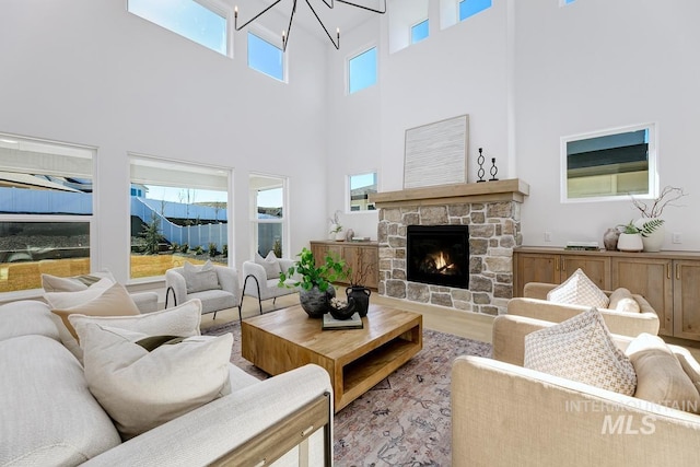 living room featuring wood finished floors, a healthy amount of sunlight, and a chandelier