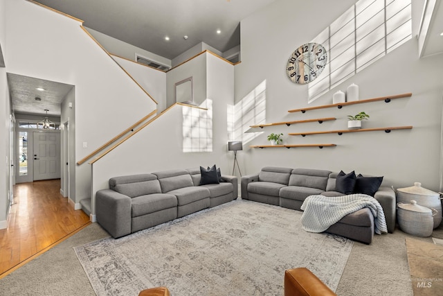 living room featuring a healthy amount of sunlight, a towering ceiling, and wood finished floors