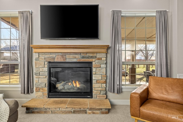 details featuring a stone fireplace, carpet flooring, and baseboards