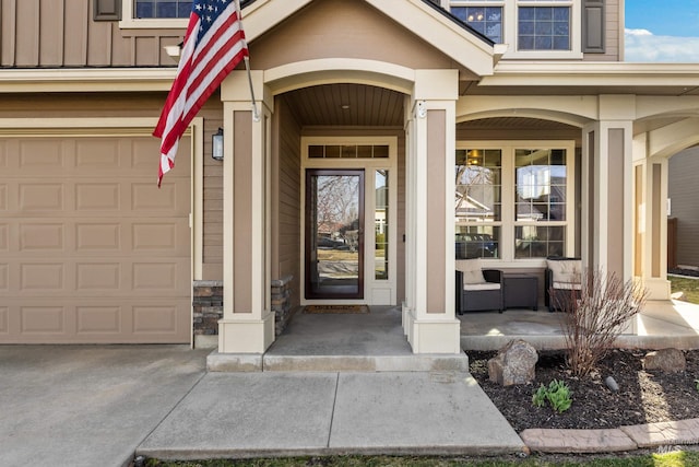 entrance to property featuring a porch, a garage, and board and batten siding