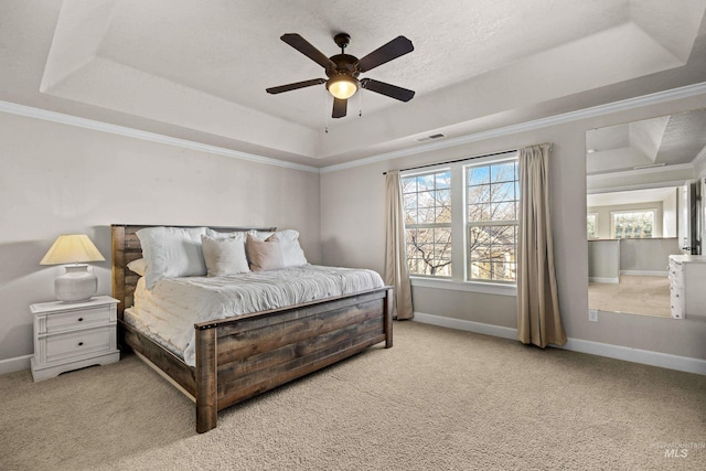 carpeted bedroom with a tray ceiling, baseboards, and visible vents