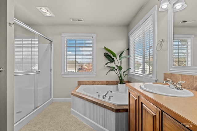 bathroom with visible vents, a stall shower, vanity, and a bath