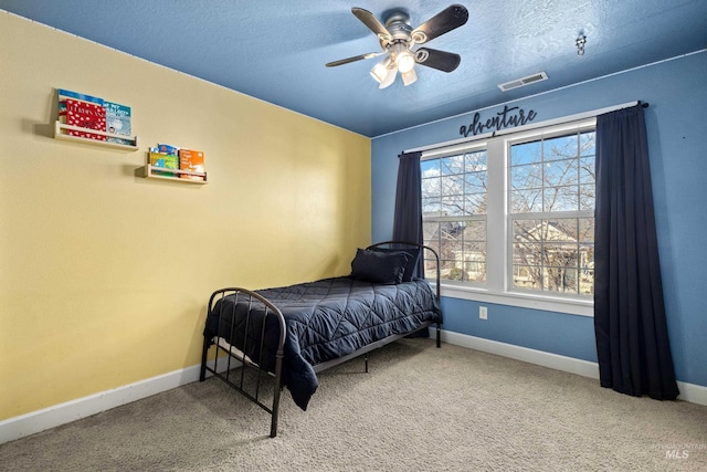 carpeted bedroom featuring visible vents, baseboards, and a textured ceiling