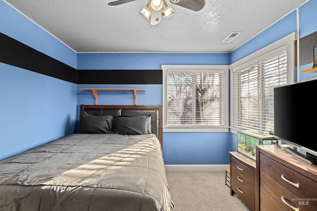 bedroom featuring a ceiling fan, baseboards, visible vents, a textured ceiling, and carpet flooring