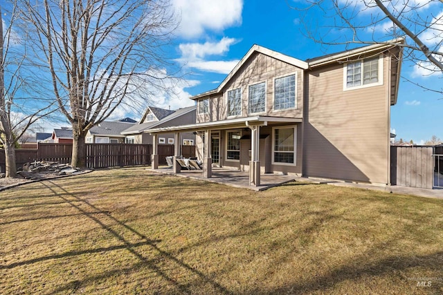 back of house featuring a yard, a fenced backyard, and a patio area