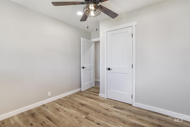 unfurnished bedroom featuring light wood-style floors, ceiling fan, and baseboards