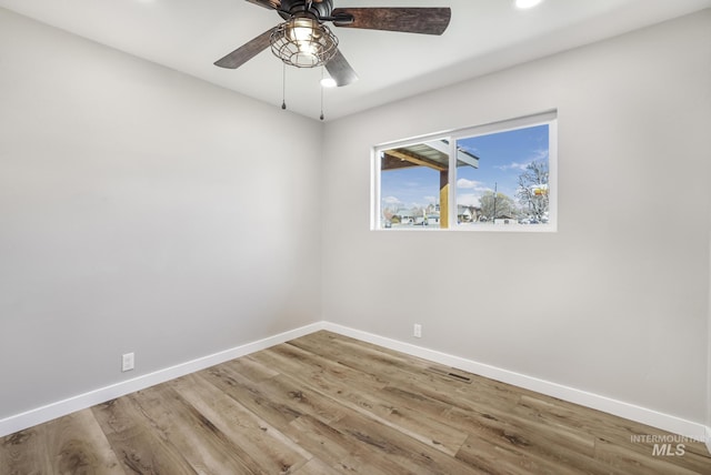 unfurnished room featuring a ceiling fan, baseboards, and wood finished floors