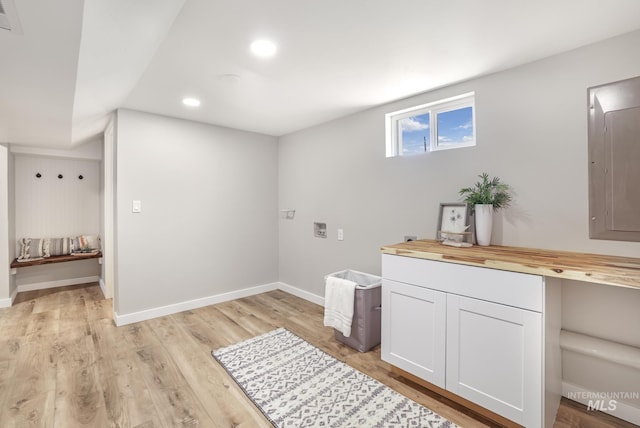 laundry room featuring recessed lighting, electric panel, light wood-style flooring, and baseboards