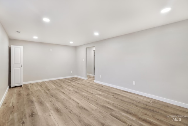 unfurnished room with light wood finished floors, baseboards, and recessed lighting