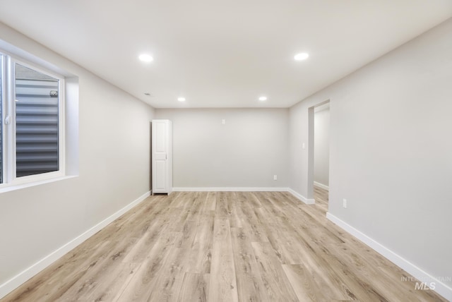 empty room with recessed lighting, light wood finished floors, and baseboards