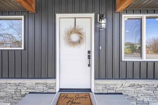 property entrance featuring stone siding and board and batten siding